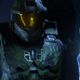 Master Chief looks at the Weapon in a dark dungeon in Halo Infinite.